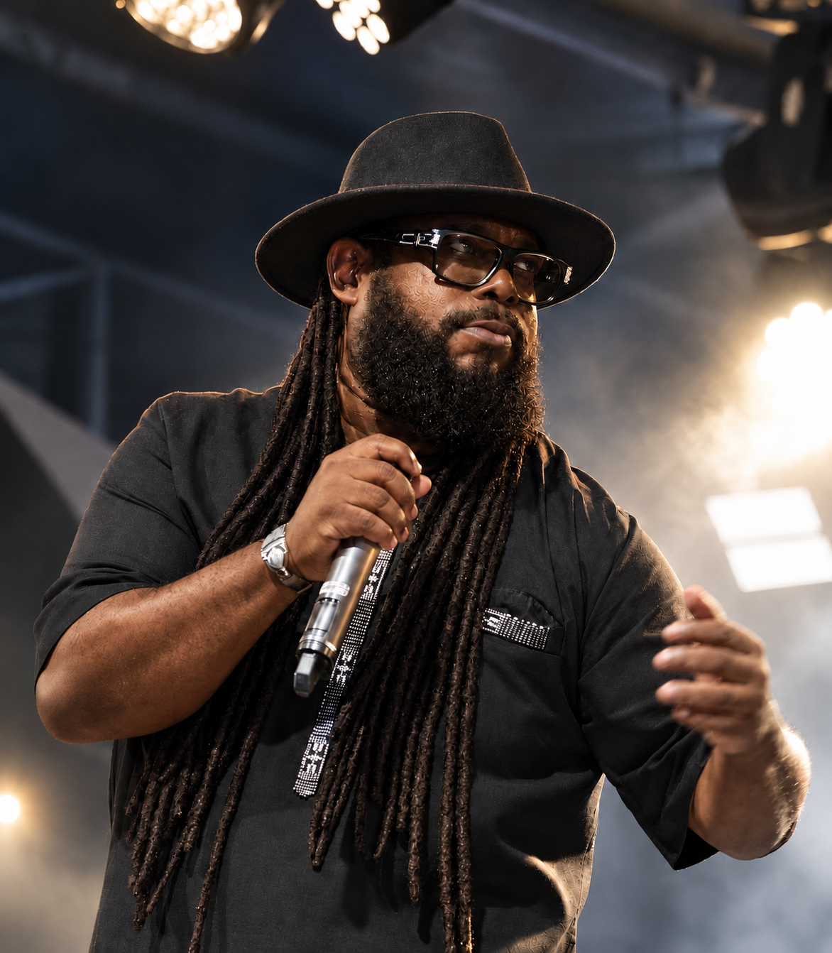 Jean-Michel SAMBA at the microphone, wearing a hat